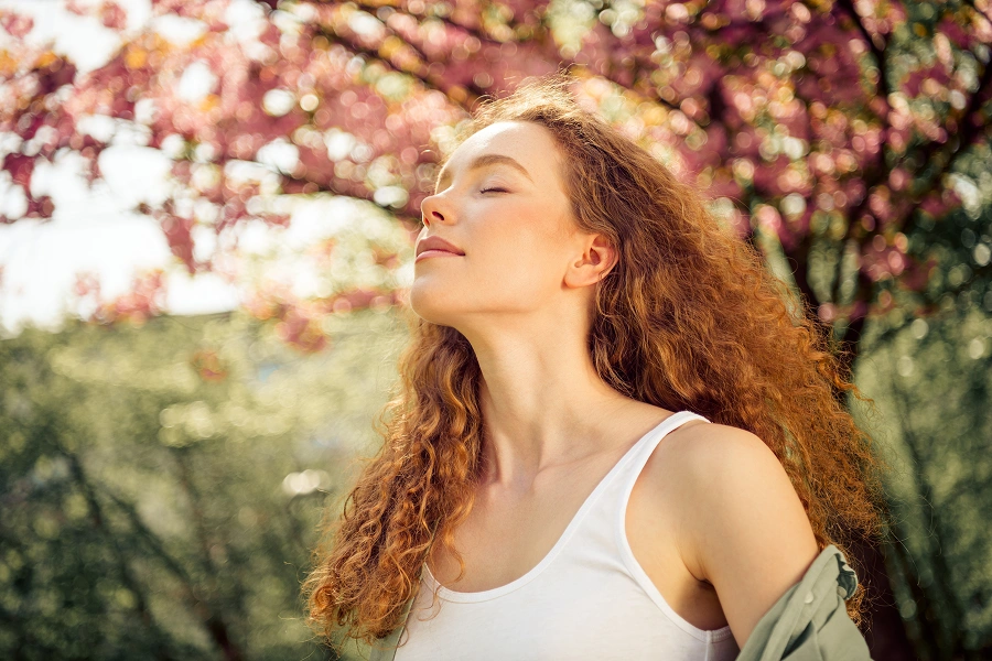 Woman enjoying springtime under blooming tree.