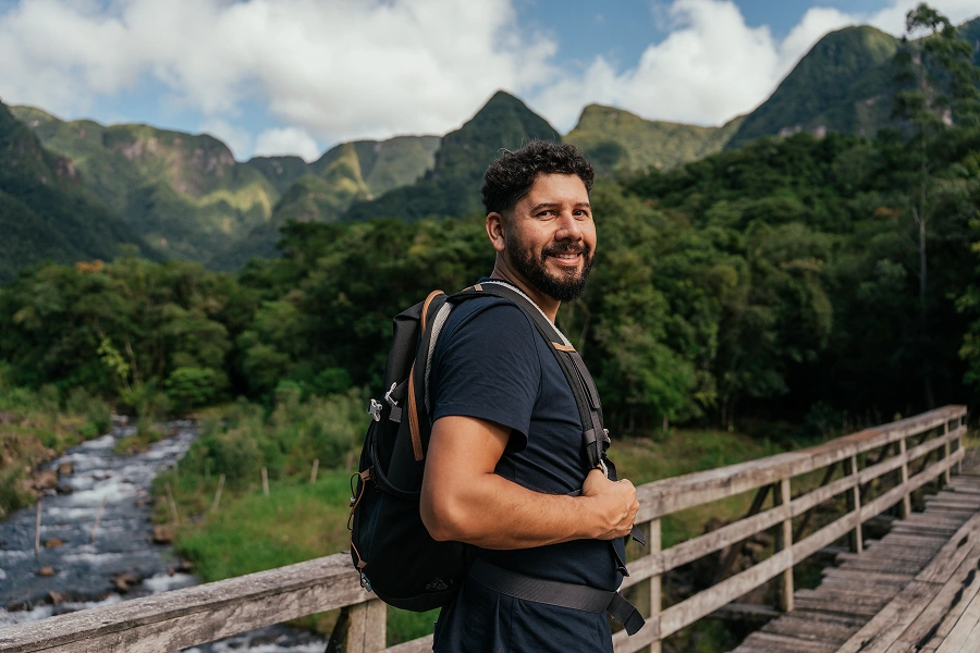 Man hiking on a bridge in mountains.