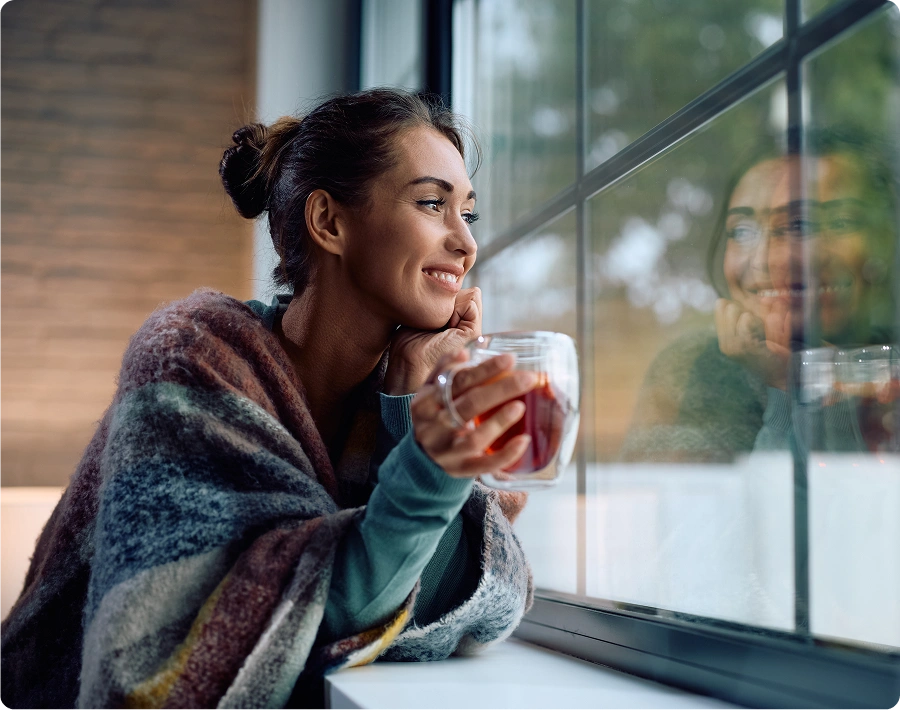 Woman enjoying a drink by the window.