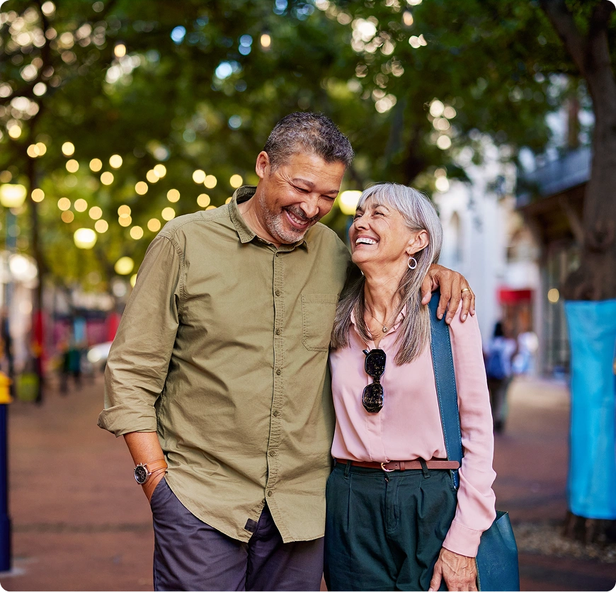 Happy couple walking and laughing together outdoors.